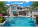 Stunning backyard with a sparkling pool, spa, covered patio, and mature palm trees at 10100 Loblolly Pine Cir, Orlando, FL 32827
