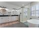 Bright bathroom with dual vanity, soaking tub, and glass-enclosed shower at 10100 Loblolly Pine Cir, Orlando, FL 32827