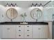 Well-lit bathroom with dual sinks, granite countertop, and decorative round mirrors at 10100 Loblolly Pine Cir, Orlando, FL 32827