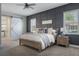Bedroom with a ceiling fan, gray carpet, and a barn door leading to the bathroom at 10100 Loblolly Pine Cir, Orlando, FL 32827