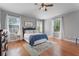 Bright bedroom with hardwood floors, a ceiling fan, and three large windows at 10100 Loblolly Pine Cir, Orlando, FL 32827