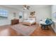 Large bedroom with hardwood floors, a papasan chair, and two windows at 10100 Loblolly Pine Cir, Orlando, FL 32827