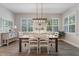 Bright dining room with modern chandelier, shutters, light walls, and wood-look floors with neutral accents at 10100 Loblolly Pine Cir, Orlando, FL 32827
