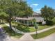 Beautiful two-story home featuring a charming front porch, lush landscaping, and mature trees at 10100 Loblolly Pine Cir, Orlando, FL 32827