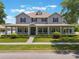 Charming two-story home featuring a spacious front porch, manicured lawn, and beautiful landscaping at 10100 Loblolly Pine Cir, Orlando, FL 32827