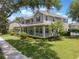 Charming two-story home featuring a spacious front porch, manicured lawn, and beautiful landscaping at 10100 Loblolly Pine Cir, Orlando, FL 32827