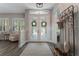 Elegant foyer with decorative glass doors, wood floors, and a welcoming bench and coat rack at 10100 Loblolly Pine Cir, Orlando, FL 32827