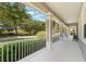 Spacious front porch with classic white railings and columns, offering a charming outdoor seating area at 10100 Loblolly Pine Cir, Orlando, FL 32827