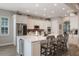 Modern white kitchen with stainless steel appliances, large island with seating, and a brick backsplash detail at 10100 Loblolly Pine Cir, Orlando, FL 32827