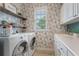 Laundry room with side by side washer and dryer and floral wallpaper at 10100 Loblolly Pine Cir, Orlando, FL 32827