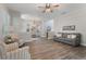 Spacious living room with wood-look flooring, grey sofa, two striped chairs, and open access to other rooms at 10100 Loblolly Pine Cir, Orlando, FL 32827
