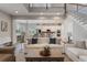Well lit living room showing the open floor plan, staircase and kitchen with white cabinets and stainless appliances at 10100 Loblolly Pine Cir, Orlando, FL 32827