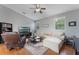 Cozy living room featuring plush seating, ceiling fan and large windows for natural light at 10100 Loblolly Pine Cir, Orlando, FL 32827
