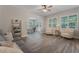 Bright living room featuring wood-look tile floors, modern furniture, and light neutral walls with bright natural light at 10100 Loblolly Pine Cir, Orlando, FL 32827