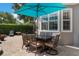 Outdoor dining area on a brick patio with a teal umbrella, perfect for entertaining at 10100 Loblolly Pine Cir, Orlando, FL 32827