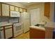 Well-equipped kitchen featuring white appliances, updated tile backsplash, and ample storage at 1051 S Hiawassee Rd # 2136, Orlando, FL 32835