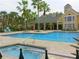 Community pool with a jacuzzi, sun loungers, lush landscaping, and a recreation area at 1051 S Hiawassee Rd # 2136, Orlando, FL 32835
