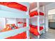 Quaint bedroom featuring two sets of bunkbeds with bright red bedding and access to an en suite bathroom at 109 Kenny Blvd, Haines City, FL 33844