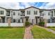 Inviting townhouse exterior with manicured lawn, brick pathway, gated entry, and private balconies at 109 Kenny Blvd, Haines City, FL 33844