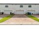 Townhouse garages with neat brick driveways and trimmed greenery for a clean, organized look at 109 Kenny Blvd, Haines City, FL 33844