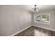 Bright bedroom with natural light from a large window, complemented by modern flooring and a stylish fan at 11572 Se 60Th Ave, Belleview, FL 34420