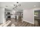 Open-concept kitchen featuring sleek, modern appliances, white cabinets, and stylish light fixtures at 11572 Se 60Th Ave, Belleview, FL 34420