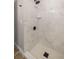 The updated shower features sleek marble-look tile, black hardware, and a contemporary design at 11572 Se 60Th Ave, Belleview, FL 34420