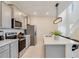 Modern kitchen with gray cabinets, stainless steel appliances, and a sleek breakfast bar at 1221 Aloha Blvd, Davenport, FL 33897