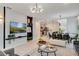 Open-concept living space featuring a modern chandelier, decorative wall, and seamless flow to the kitchen and dining area at 1221 Aloha Blvd, Davenport, FL 33897