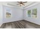 Bedroom with wood-look flooring, a tray ceiling, and natural light from two windows at 12691 Calderdale Ave, Windermere, FL 34786