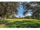 Scenic view of the community park with a large lawn, trees, and a charming clubhouse at 12691 Calderdale Ave, Windermere, FL 34786