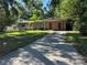 Inviting single-story home featuring a well-maintained lawn, covered parking, and mature trees at 1420 Bethesda St, Apopka, FL 32703