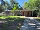Charming single-story home with mature trees, front lawn, and covered parking area at 1420 Bethesda St, Apopka, FL 32703