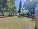 Lush backyard with green grass, a playset, and mature trees providing ample shade at 2114 Mount Vernon St, Orlando, FL 32803
