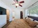 Cozy bedroom with a ceiling fan, wood floors, and a closet with custom shelving for storage at 2114 Mount Vernon St, Orlando, FL 32803