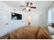 Comfortable bedroom featuring a ceiling fan, mounted TV, and an ensuite bathroom and closet at 2114 Mount Vernon St, Orlando, FL 32803