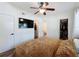 Bedroom with closet and bathroom entrances, updated flooring, ceiling fan, and a mounted tv at 2114 Mount Vernon St, Orlando, FL 32803