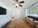 Cozy bedroom featuring a ceiling fan, mounted TV, and an ensuite bathroom and closet at 2114 Mount Vernon St, Orlando, FL 32803