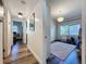Bright hallway with wood floors leading to a bedroom with a window and modern light fixture at 2114 Mount Vernon St, Orlando, FL 32803