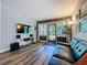 Stylish living room with hardwood floors, modern entertainment center, and views of the front yard at 2114 Mount Vernon St, Orlando, FL 32803