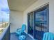 Balcony with ocean views, slider door, and relaxing blue chairs at 3100 Ocean Shore Blvd # 4030, Ormond Beach, FL 32176