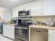 Modern kitchen featuring stainless steel appliances, white cabinets and neutral countertops at 3100 Ocean Shore Blvd # 4030, Ormond Beach, FL 32176