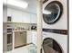 Cozy kitchen featuring stainless steel appliances and white cabinetry with an in-unit washer and dryer at 3100 Ocean Shore Blvd # 4030, Ormond Beach, FL 32176