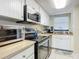 Well-lit kitchen featuring stainless steel appliances, oven, microwave and white cabinets at 3100 Ocean Shore Blvd # 4030, Ormond Beach, FL 32176