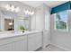 This bathroom offers double sinks with a large mirror and a window with view of the outdoors at 3156 Emerald Acres Ln, Sanford, FL 32771
