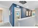 Upstairs landing with blue accent wall leading to a bedroom with lots of natural light at 3156 Emerald Acres Ln, Sanford, FL 32771