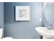 Stylish powder room features a pedestal sink, a framed picture, and a gray accent wall at 3156 Emerald Acres Ln, Sanford, FL 32771