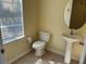 This half bathroom features a pedestal sink and a toilet at 3166 Riachuelo Ln, Kissimmee, FL 34744