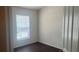 A compact bedroom with a window, laminated floors, and white walls at 3166 Riachuelo Ln, Kissimmee, FL 34744
