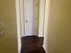 Hallway with hard wood floors and a white paneled door at the end at 3166 Riachuelo Ln, Kissimmee, FL 34744